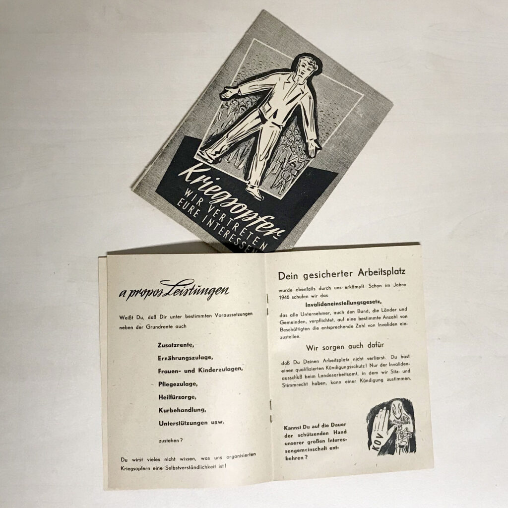 Eine Leistungsbroschüre im Stil der 1950er Jahre. Am Deckblatt ist die Grafik eines Mannes mit gespreizten Armen und Beinen zu sehen, hinter ihm eine große Gruppe menschen. Der Titel lautet "Kriegsopfer wir vertreten eure Interessen." Darunter ist die Broschüre am Mittelfalz aufgeschlagen. Zu lesen ist: A propos Leistungen. Weißt Du, dass Dir unter bestimmten Voraussetzungen neben der Grundrente auch Zusatzrente, Ernöhrungszulage, Frauen- un Kinderzulagen, Pflegezulage, Heilfürsorge, Kurbehandlung, Unterstützungen usw. zustehen? Du wirst vieles nicht wissen, was uns organisierten Kriegsopfern eine Selbstversändlichkeit ist! Auf der rechten Seite steht: Dein gesicherter Arbeitsplatz wurde ebenfalls durch uns erkämpft. Schon im Jahre 1946 schufen wir das Invalideneinstellungsgesetz, das alle Unternehmer, auch den Bund, die Länder und Gemeinden, verpflichtet, auf eine bestimmte Anzahl von Beschäftigten die entsprechende Zahl von Invaliden einzustellen. Wir sorgen auch dafür, dass Du deinen Arbeitsplatz nicht verlierst. Du hast einen qualifizierten Kündigungsschutz! Nur der Invalidenausschuss beim Landesarbeitsamt, in dem wir Sitz- und Stimmrecht haben, kann einer Kündigung zustimmen. Kannst du auf die Dauer der schützenden Hand unserer großen Interessensgemeinschaft entbehren?